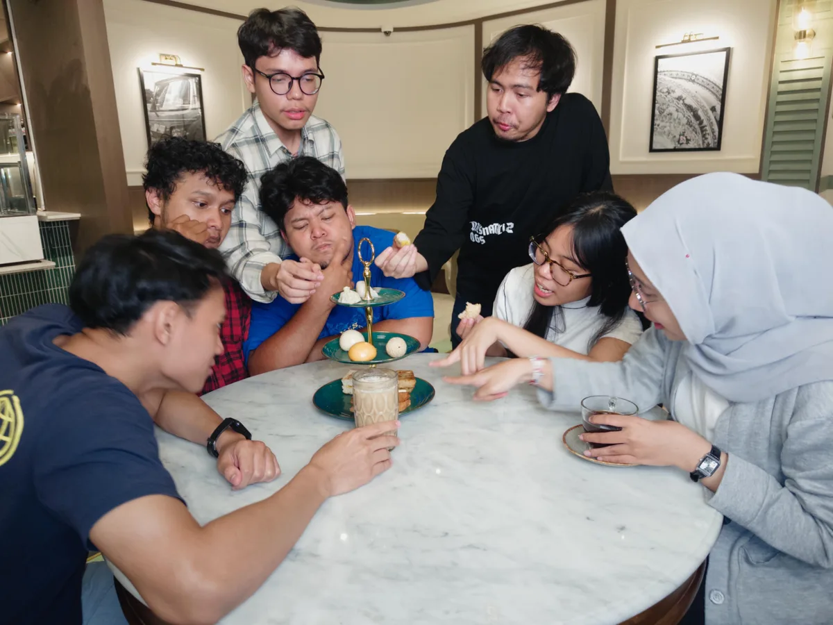 Friends sharing kopi, toast and dim sum around a table