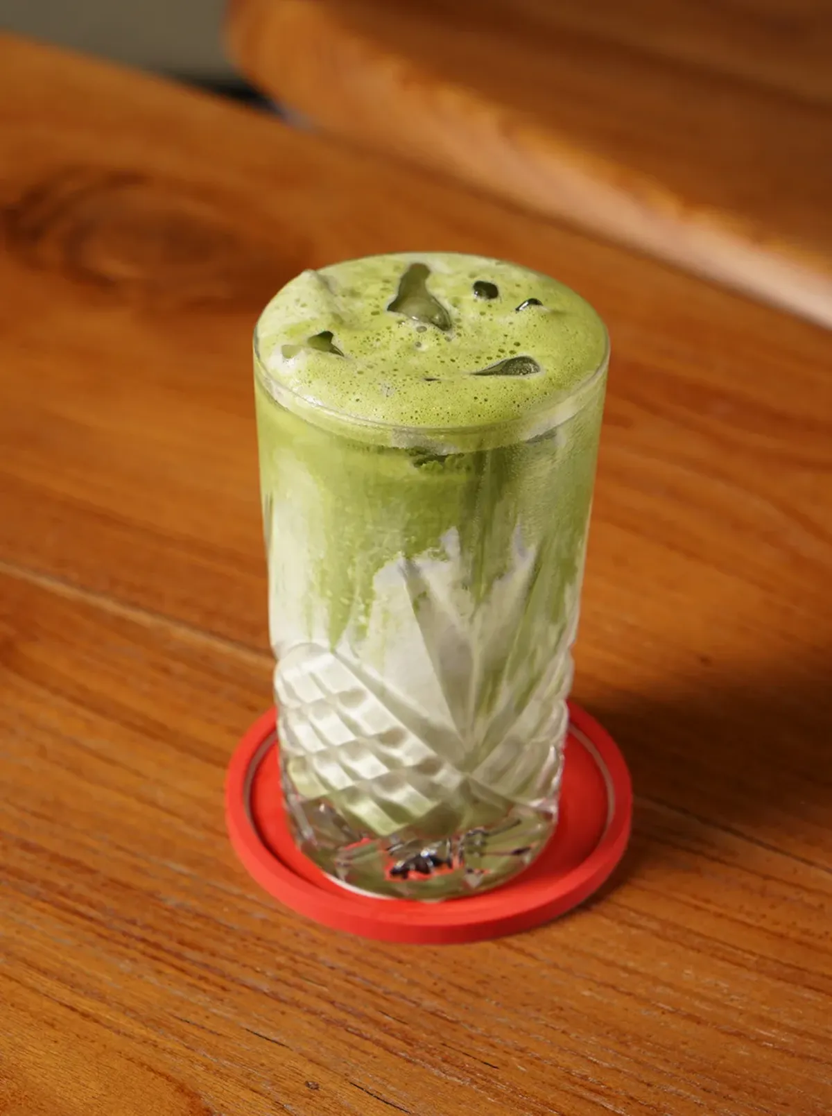 An iced matcha latte on a wooden table